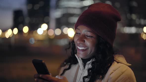 Woman Look at Mobile Phone Digital Device at Night Outdoors in a City