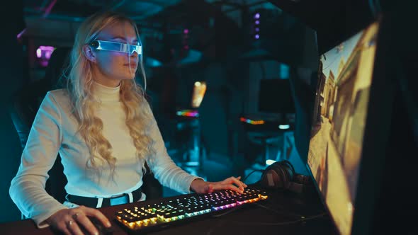 Blonde Streamer Playing Shooter in Neon 3D Glasses