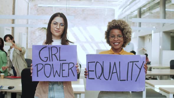 Two Women in an Office with a Sign with the Slogan Girl Power