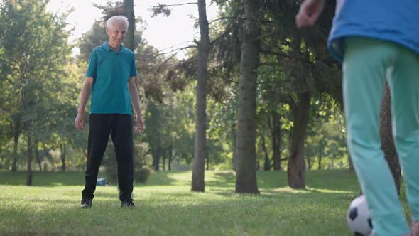 Wide Shot Joyful Man Passing Soccer Ball with Woman in Sunny Park Smiling