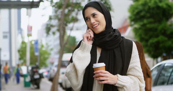 Woman in hijab using mobile phone in the city 