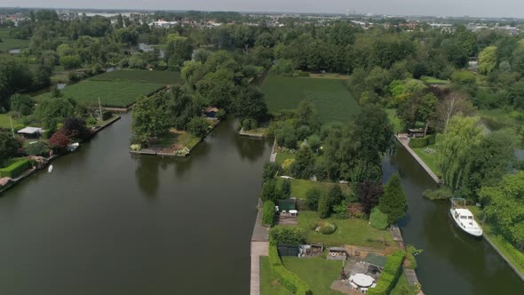 Aerial Slomo of Dutch Countryside surrounded with Small Rivers, Green Trees and Bushes,with Small To
