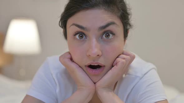 Portrait of Young Indian Woman Feeling Shocked towards Camera in Bed