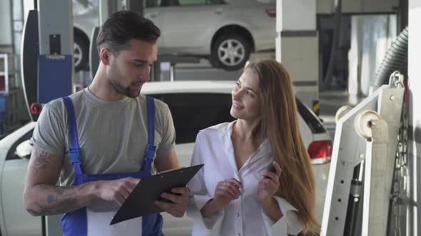 Mechanic and Customer or Car Owner Signing Pape