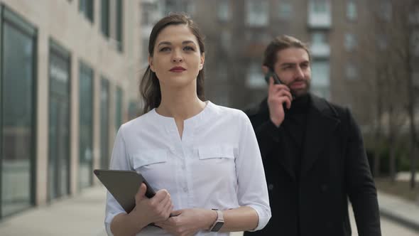 Confident Businesswoman Walking Down the Street with Her Partner