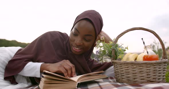 Black Woman in White Dress Reading at the River Bank