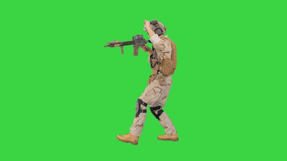 Soldier Walking Aiming with Rifle and Using Radio on a Green Screen, Chroma Key