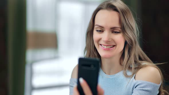 Happy Young Blonde Girl Enjoying Video Chatting with Friend