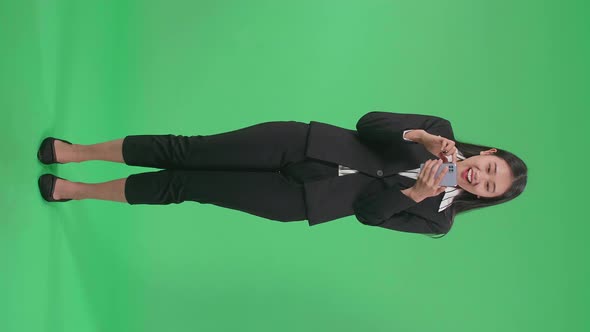 Full Body Of Asian Business Woman Enjoy Using Mobile Phone And Say Wow On Green Screen In The Studio