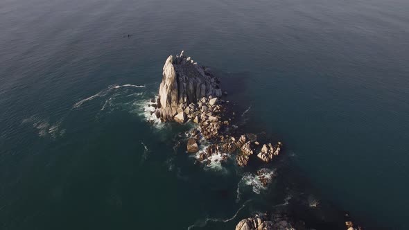 Aerial View of a Beautiful Small Rocky Island Surrounded By Clear Blue Sea