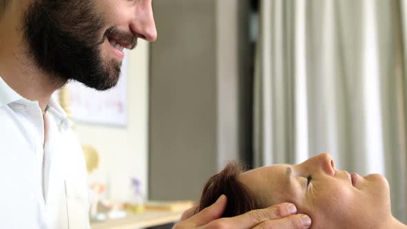 Physiotherapist giving head massage to a female patient