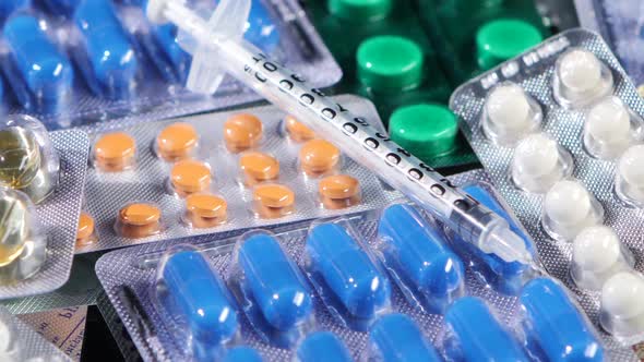 Some Different Contraceptive Pills and Syringe, Rotation, Reflection, Close Up