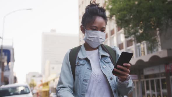 Mixed race woman wearing coronavirus medical mask on the street