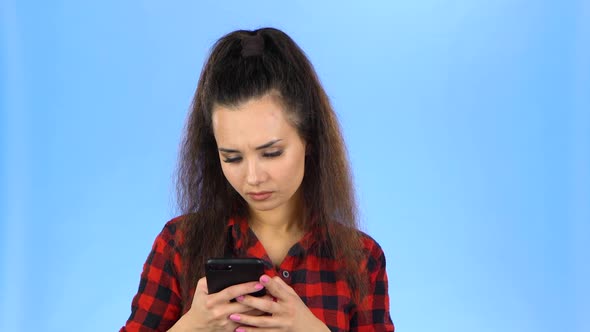 A Lady Looking at Her Phone and Becoming Surprised