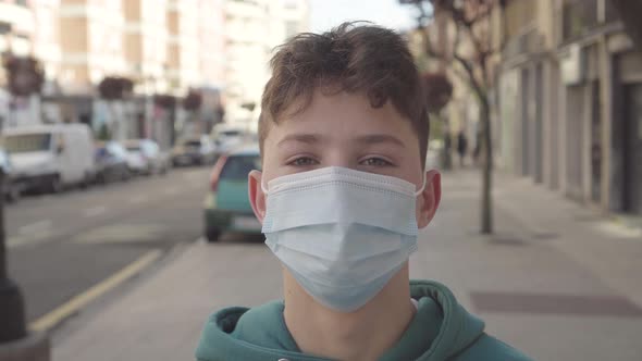 A teenager opens his eyes while standing in a medical protective disposable mask