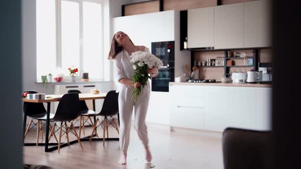 Beauty Delicate Woman Enjoys a Bouquet of White Flowers