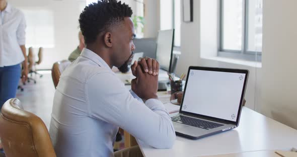 African american businessman using laptop with copy space in creative office