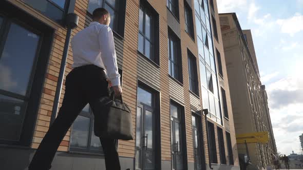 Young Confident Entrepreneur in Formal Wear Walking Near Modern Office Building