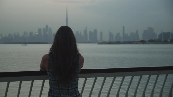 Woman Looking at Dubai Skyscrapers Across the Water