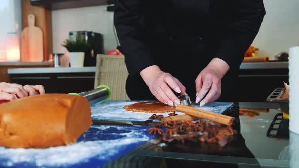 Woman Showing Her Child How To Make Gingerbread Cookies