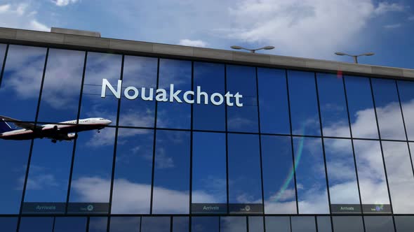 Airplane landing at Nouakchott Mauritania airport mirrored in terminal