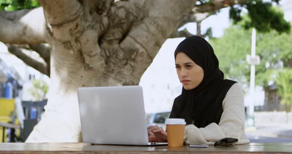 Attentive Woman in Hijab Using Laptop 4k