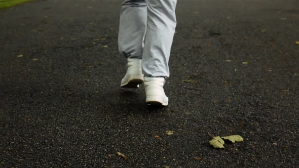 Man Legs in Sport Shoes Start To Run on Asphalt Road.