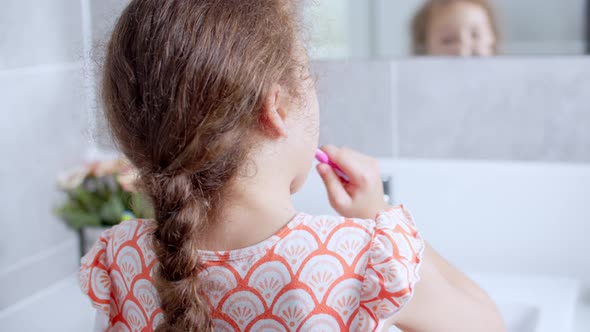 Portrait Happy Cute Young Teenage Girl Brushing Teethin the Morning in Bathroom and Smiling