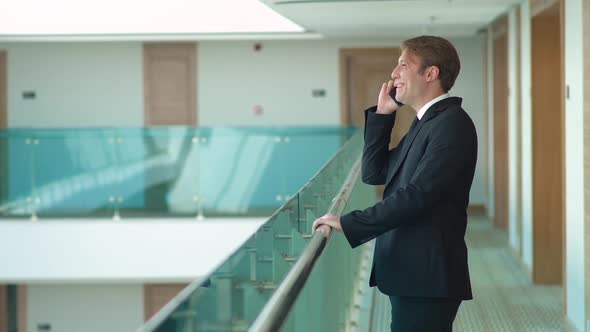 Businessman talking on the phone in the hallway.