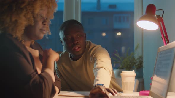 African American Colleagues Working in Office in Evening