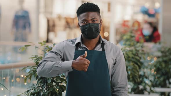Young Confident African American Man Standing in Medical Mask Waiter in Apron Shop Assistant Cafe