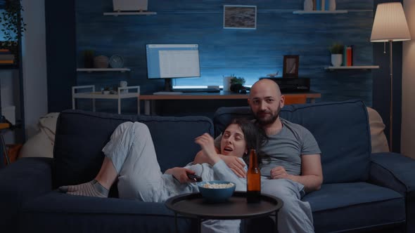 Relaxed Couple at Home Sitting on Couch Watching TV Shows