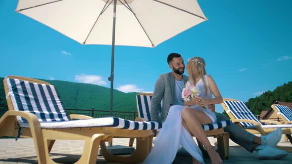 Man and girl at a resort in a hotel under a beach umbrella