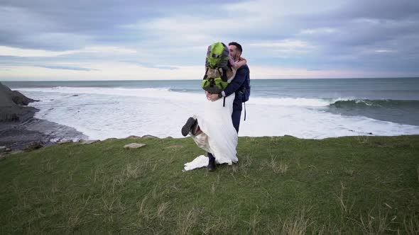 Slow motion shot of bridal couple embracing on viewpoint