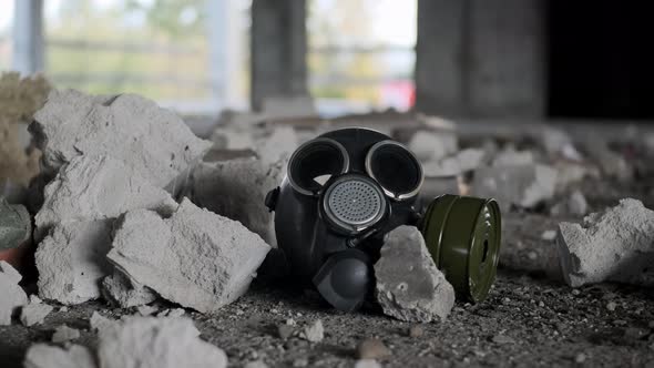 Gas Mask Lies in Abandoned Building Among Rubble of Concrete and Walls