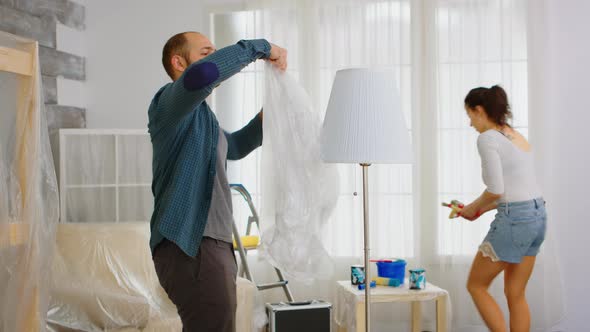 Man Wrapping Lamp with Plastic Poil