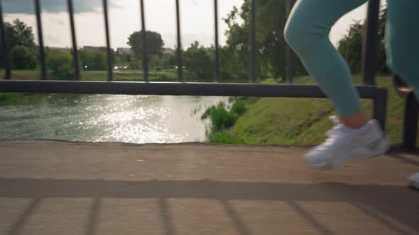 Closeup View of Female Feet Running on an Asphalt Road Into the Sunset