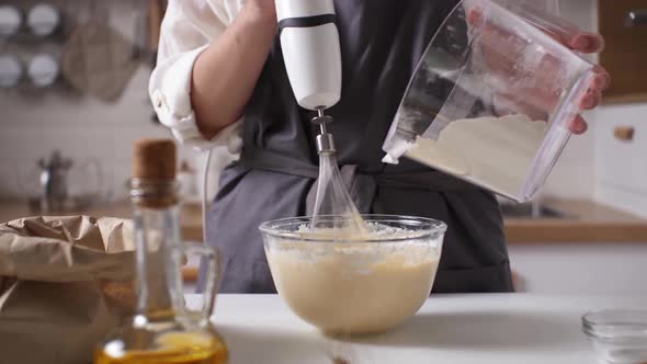 The Chef Kneads The Dough With An Electric Blender Adding Flour. Kneading Dough Preparation