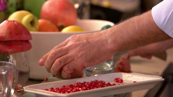 Chef Peeling Pomegranate at Kitchen of Restaurant.
