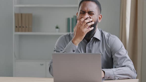 Tired Clerical African American Worker Sit at Desk with Laptop Falling Asleep Feels Unmotivated