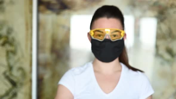 A Girl in a Protective Mask Glasses and Gloves Spray an Antiseptic To Prevent Infection