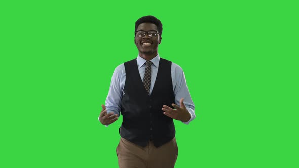 Young African American Businessman Gesturing and Talking To Camera While Walking on a Green Screen