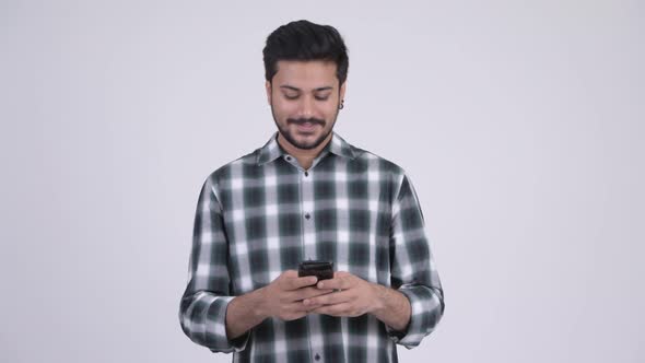 Portrait of Young Happy Bearded Indian Man Using Phone