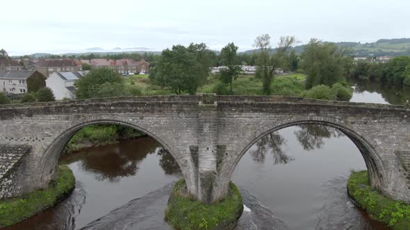 Slow motion, flying up while looking down at the Stirling Old Bridge in Scotland