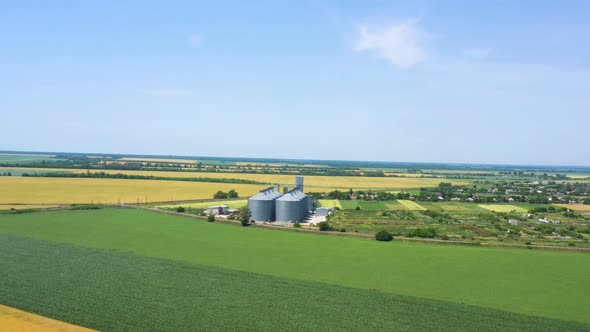 Modern Grain Silos At The Field Of Golden Wheat