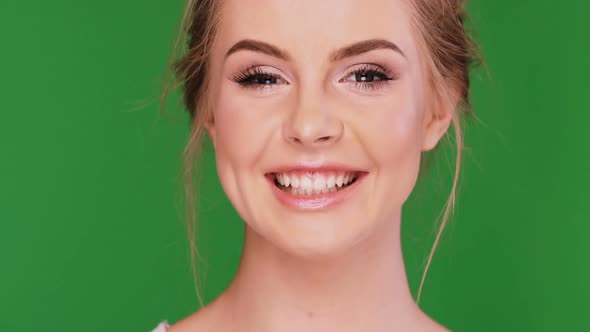 Slow Motion of Smiling Female Face Isolated on Green