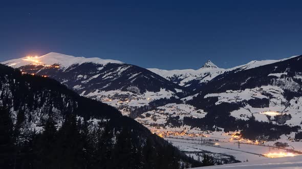 Time lapse of mountain panorama of a snowy ski resort at night. Zoom-out.