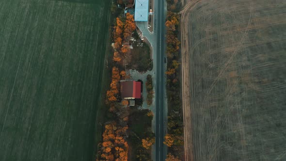 Aerial View of a Gas Station Near a Rural Road Without Cars Surrounded By Fields in the Twilight
