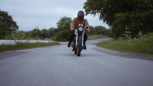 Tracking Shot of a Motorcycle Driven on a Tight Road on a Clear Skies alt