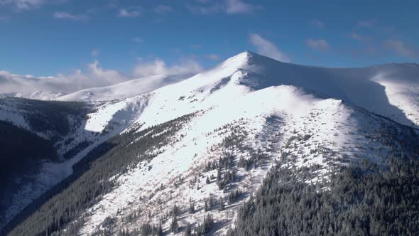 Drone flying towards snow covered mountain top